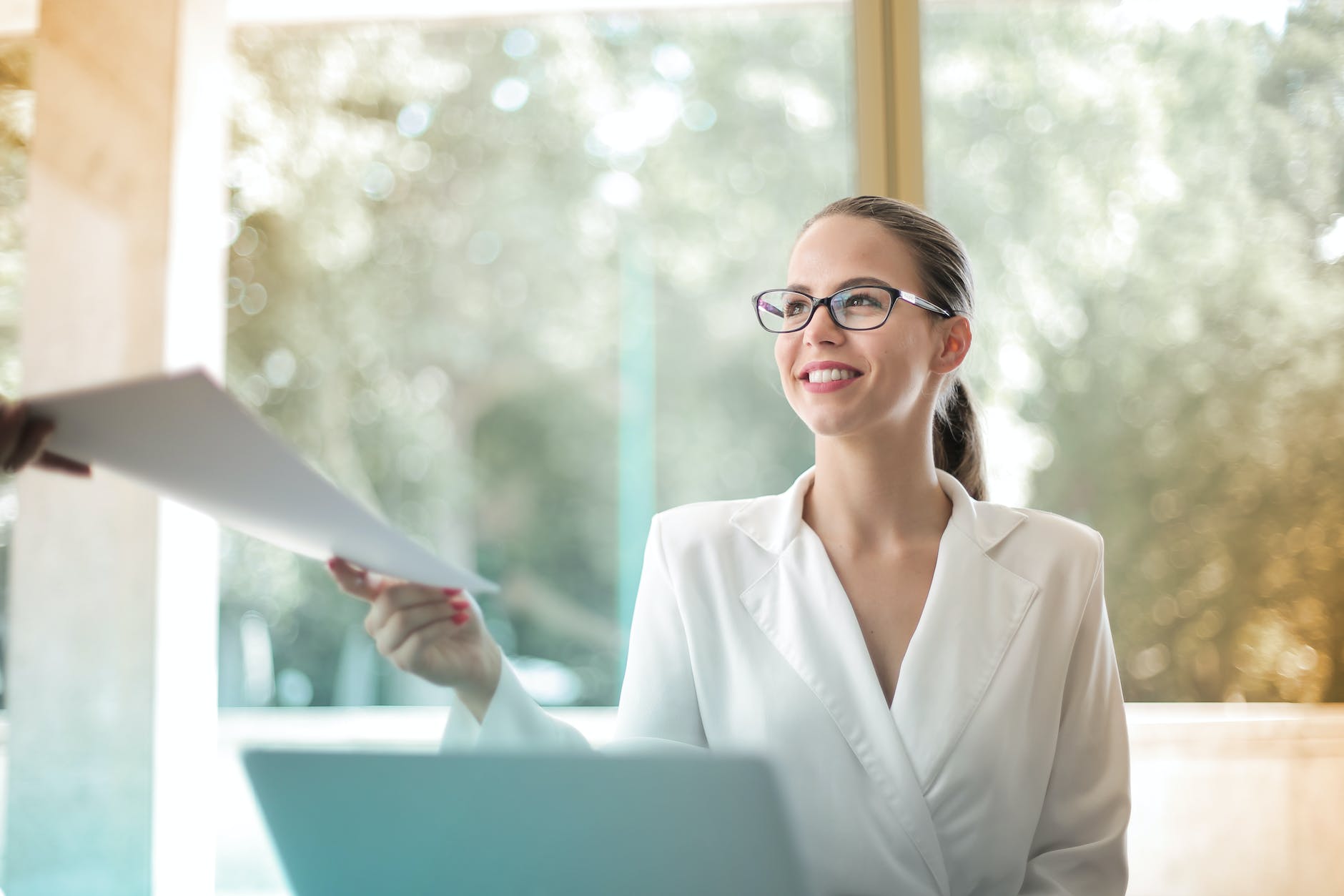 positive businesswoman doing paperwork in office | Workplace Etiquette: 6 Professional Tips for Female Managers